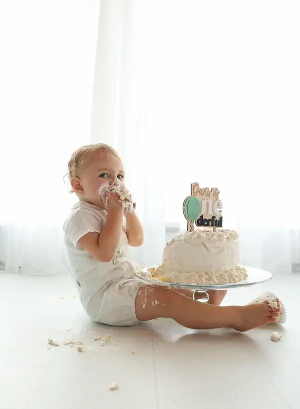 Baby smashing a birthday cake in a white studio, studio photography by Photoholic, Monsey NY